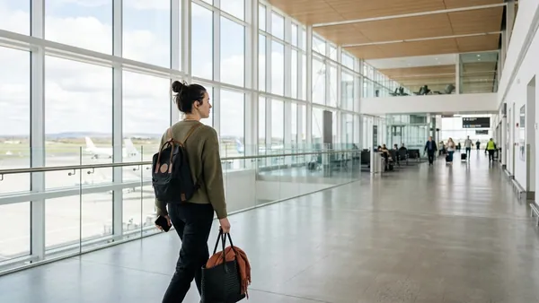 Traveller with compliant under-seat backpack in Dublin Airport terminal during Aer Lingus check-in