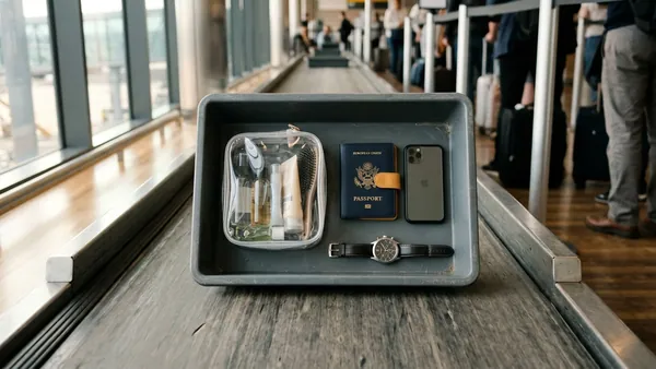 Airport security tray with clear liquids bag and travel essentials at UK departure gate